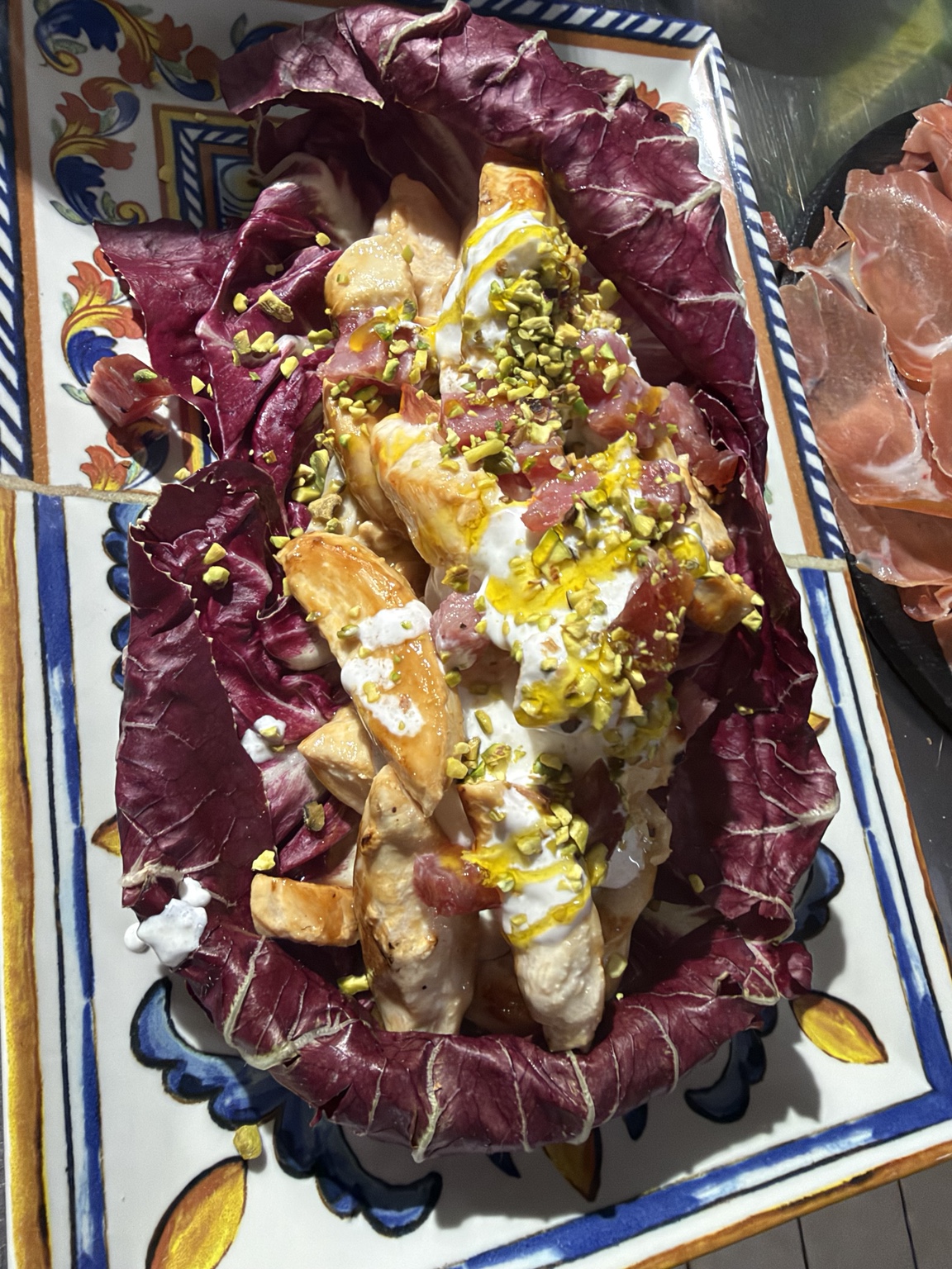 Insalata con pollo, crema e pistacchio servita su piatto decorato